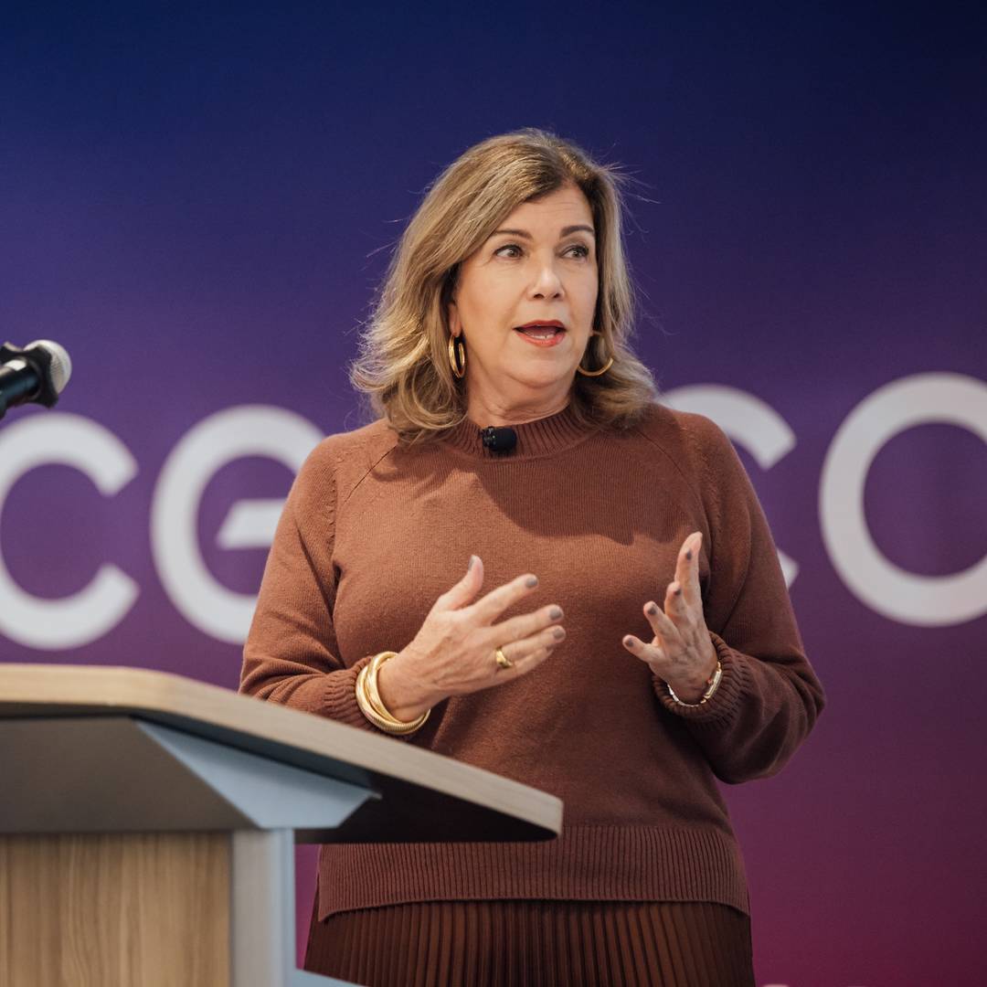 Gina K. Clark, the Executive Vice President and Chief Communications and Administration Officer of Cencora, speaking at a podium during a corporate event.